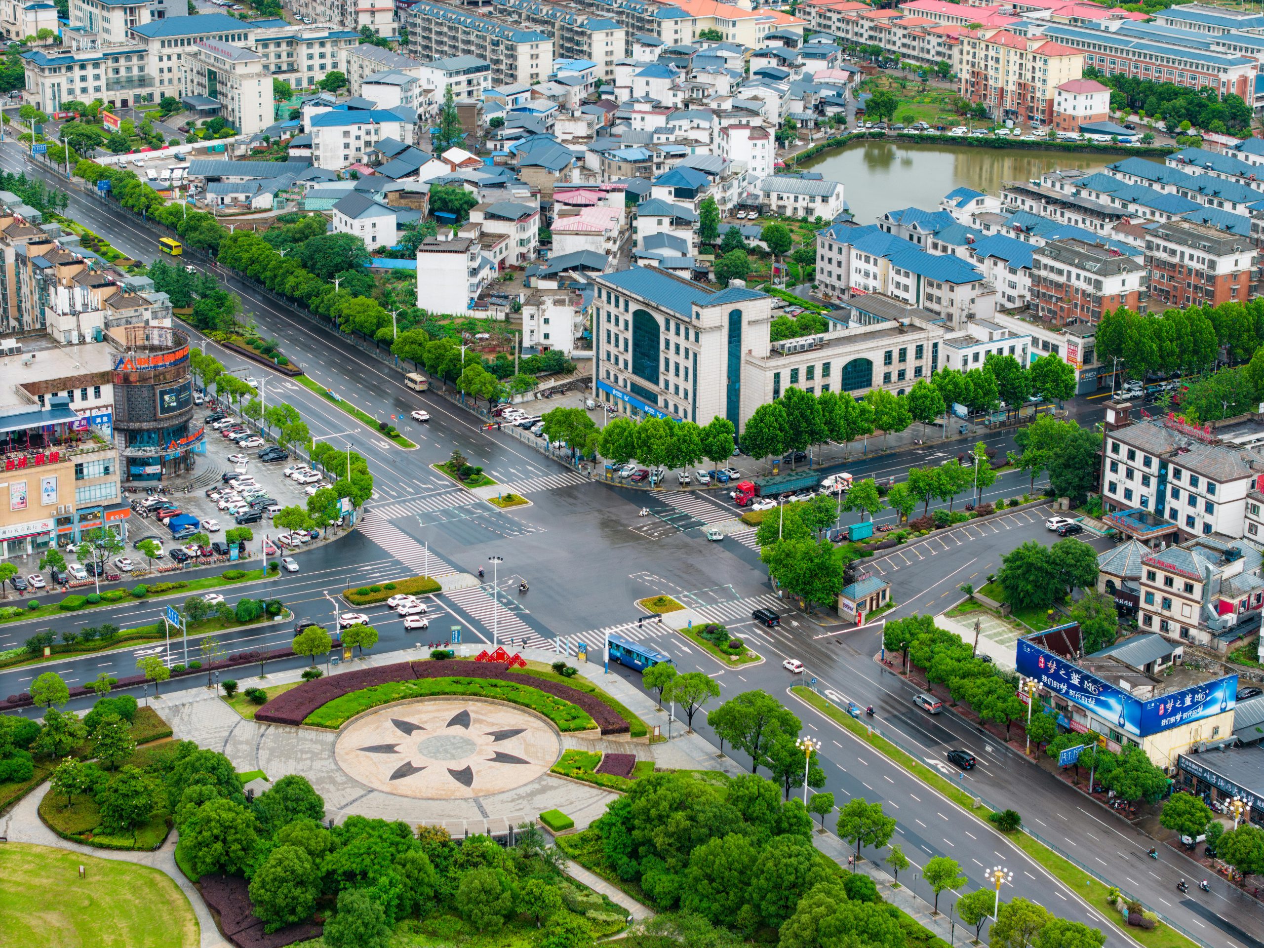 Aerial view of a modern cityscape in China with roads, buildings, and greenery.